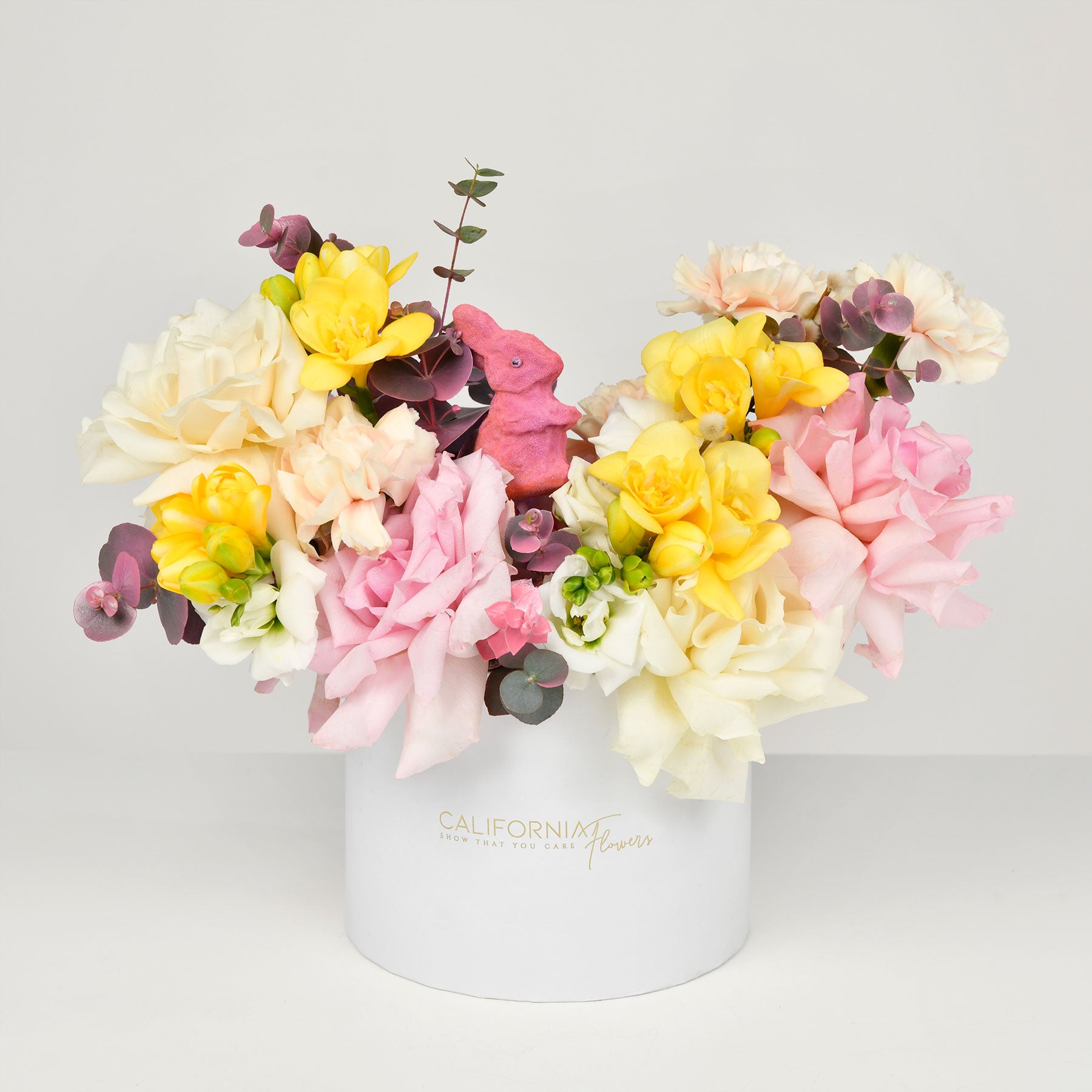 Flori de Paste - California Flowers, Aranjament floral in cutie cu frezii galbene si trandafiri multicolori, Californiaflowers.ro