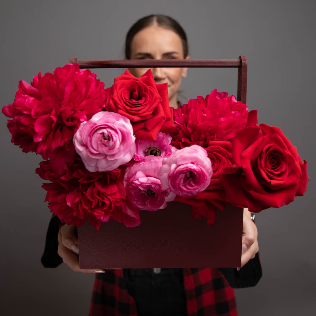 Aranjament floral in cutie cu bujori, trandafiri si ranunculus roz