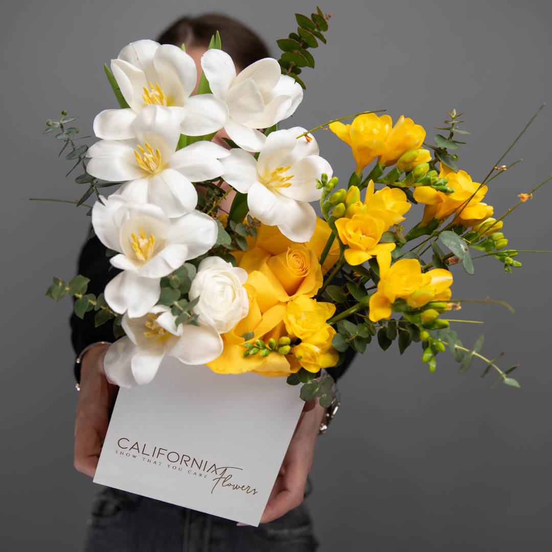 Arrangement in a box with tulips and freesias