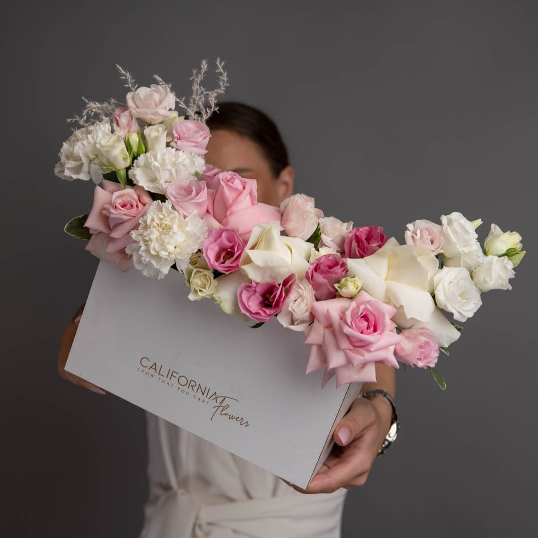 Arrangement in a box with roses and pink lisianthus