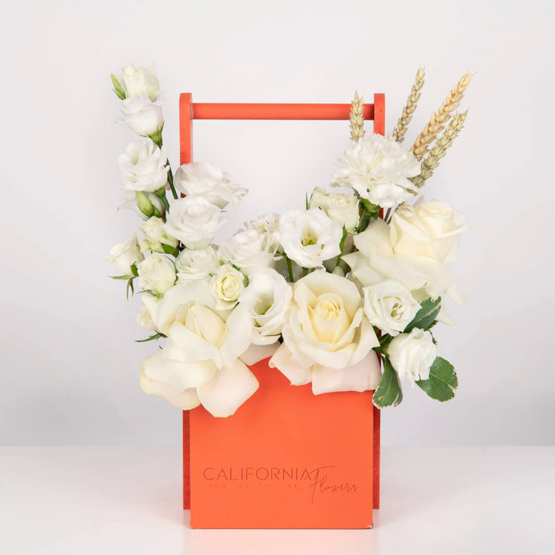 White arrangement in a box with roses and lisianthus