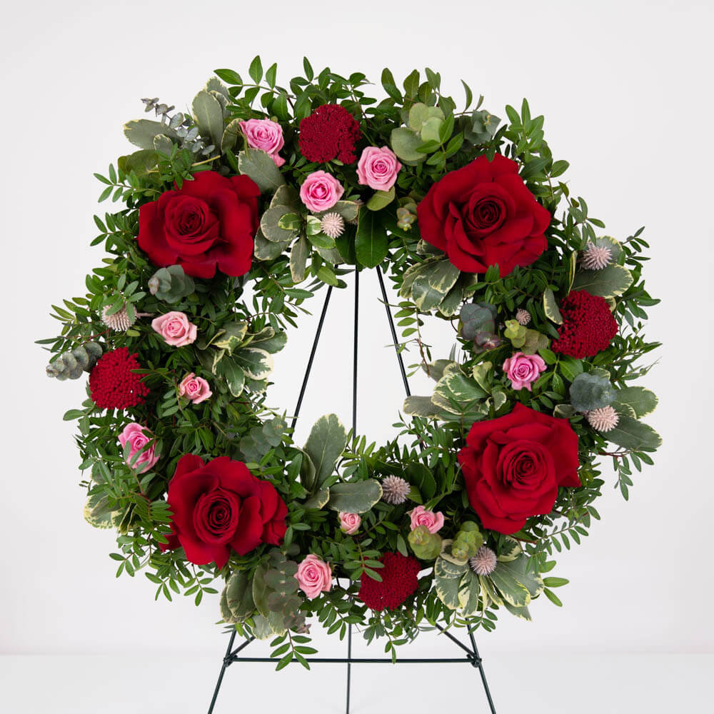 Funeral Wreath with red roses and pink ribbon