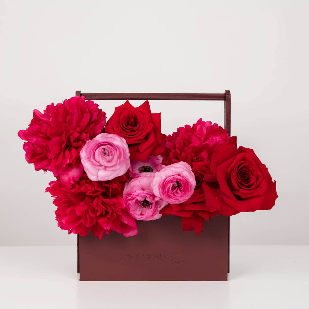Arrangement in a box with peonies, roses and ranunculus