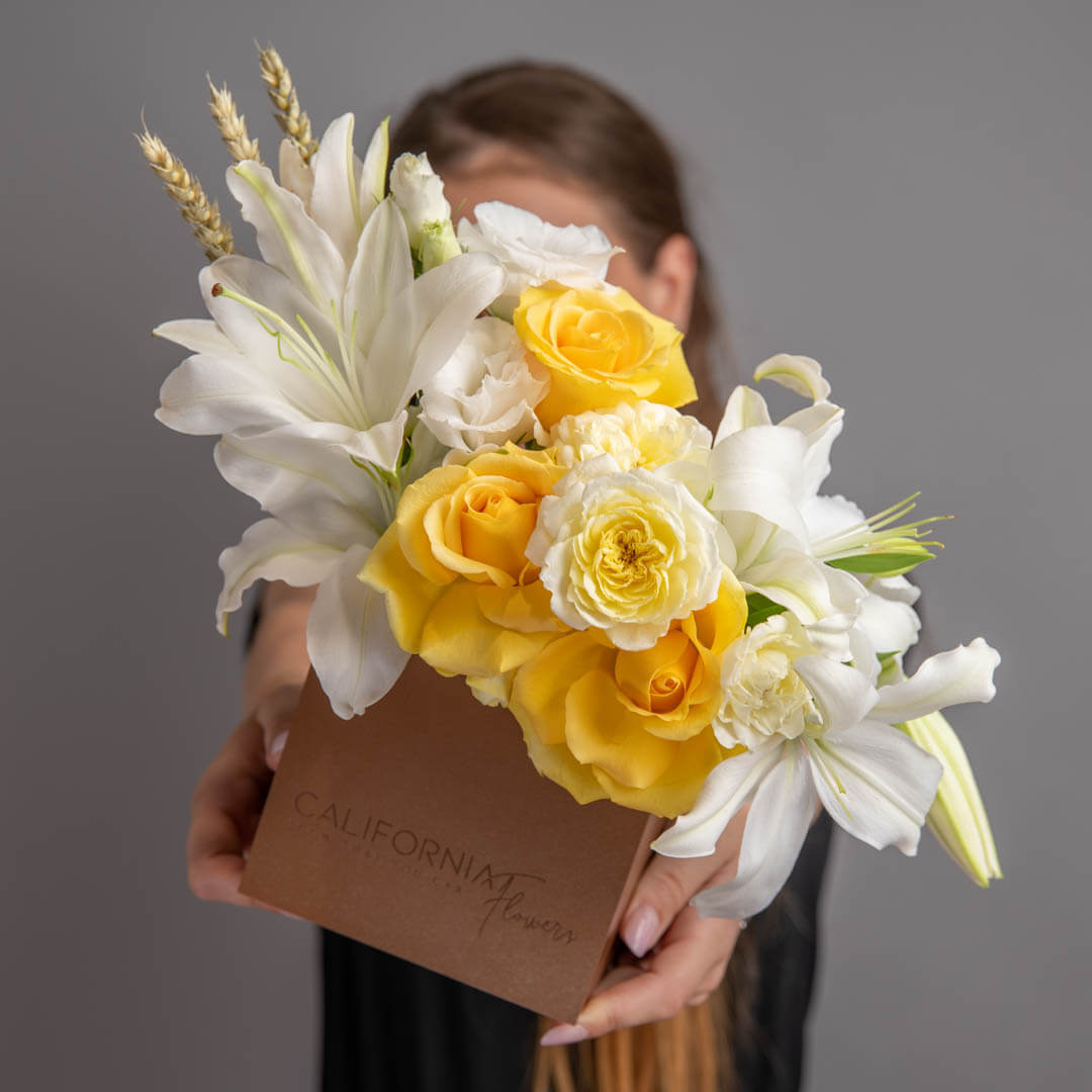 Arrangement in a box with lilies and yellow roses